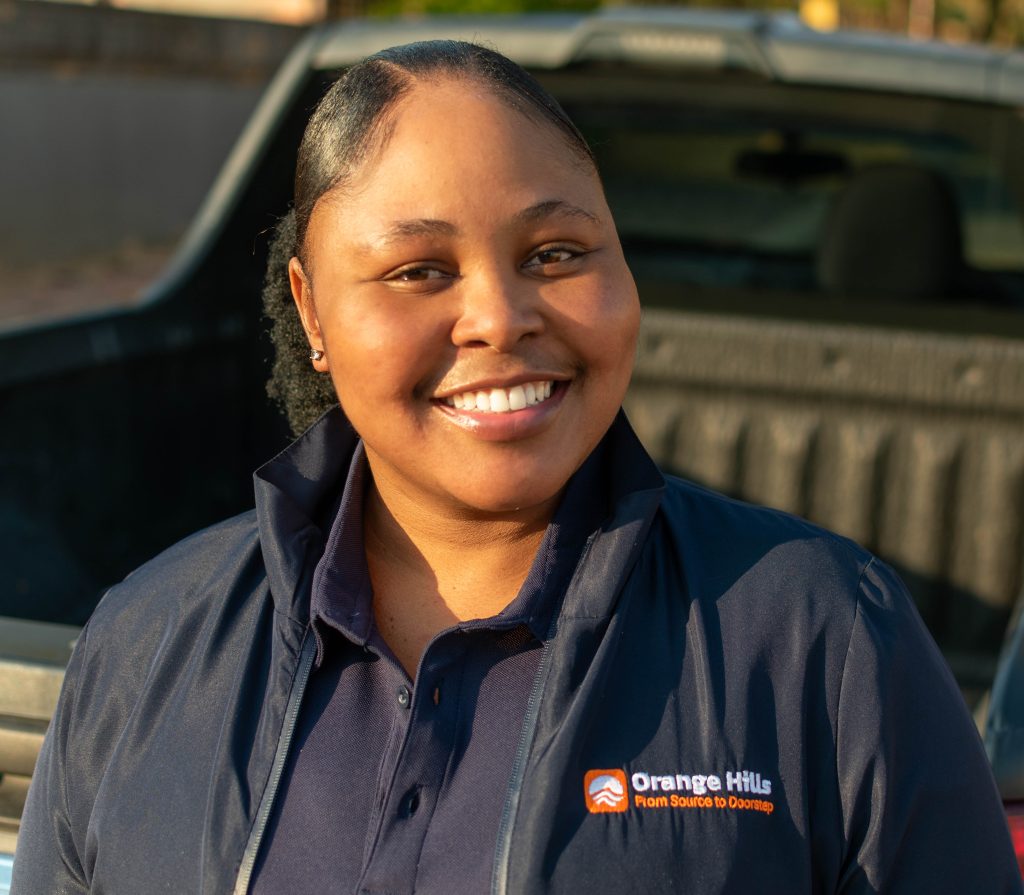 Founder Nthabiseng Mashaba standing with a water bottle, representing Orange Hills, a new water delivery service in Benoni