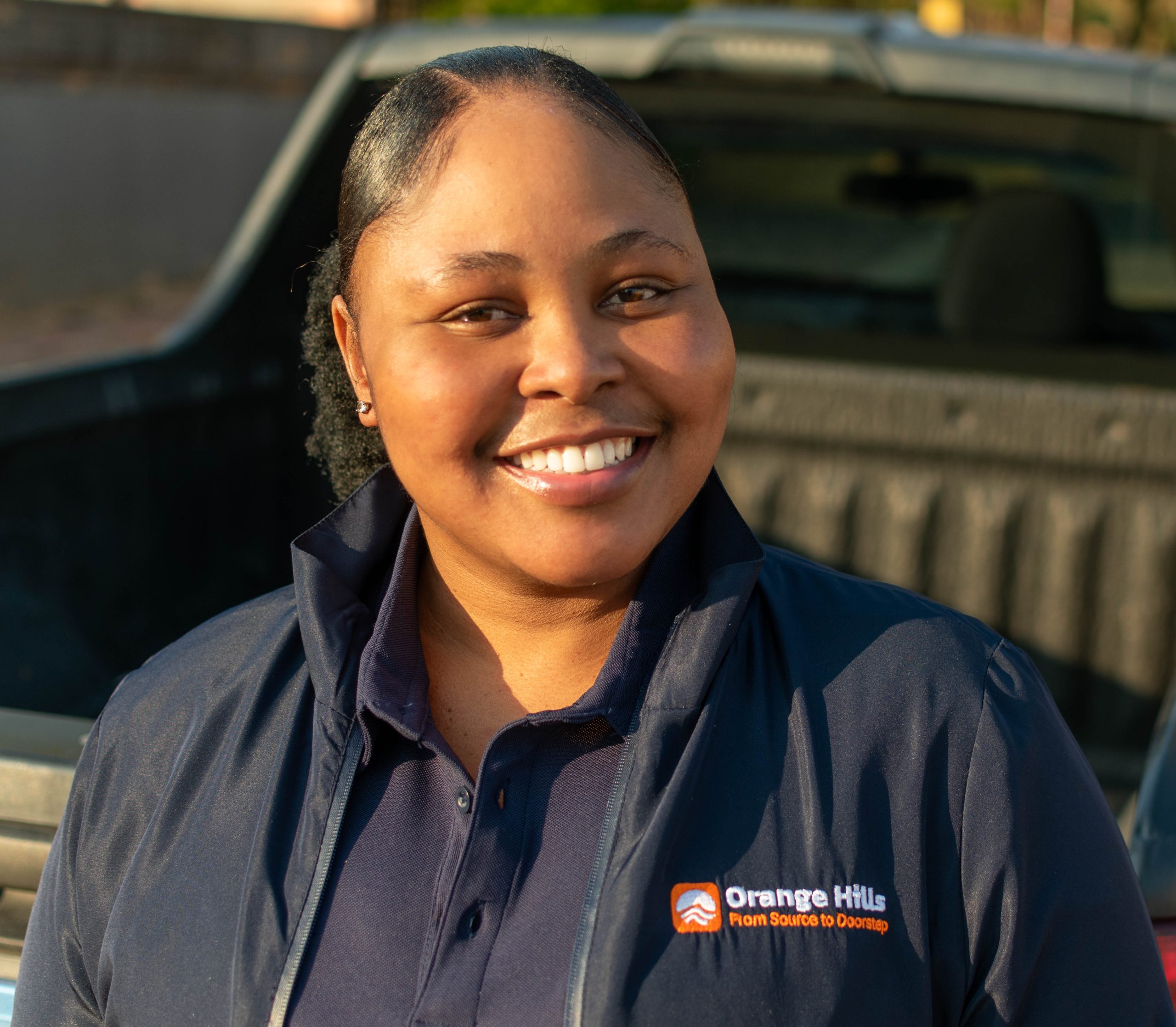 Founder Nthabiseng Mashaba standing with a water bottle, representing Orange Hills, a new water delivery service in Benoni